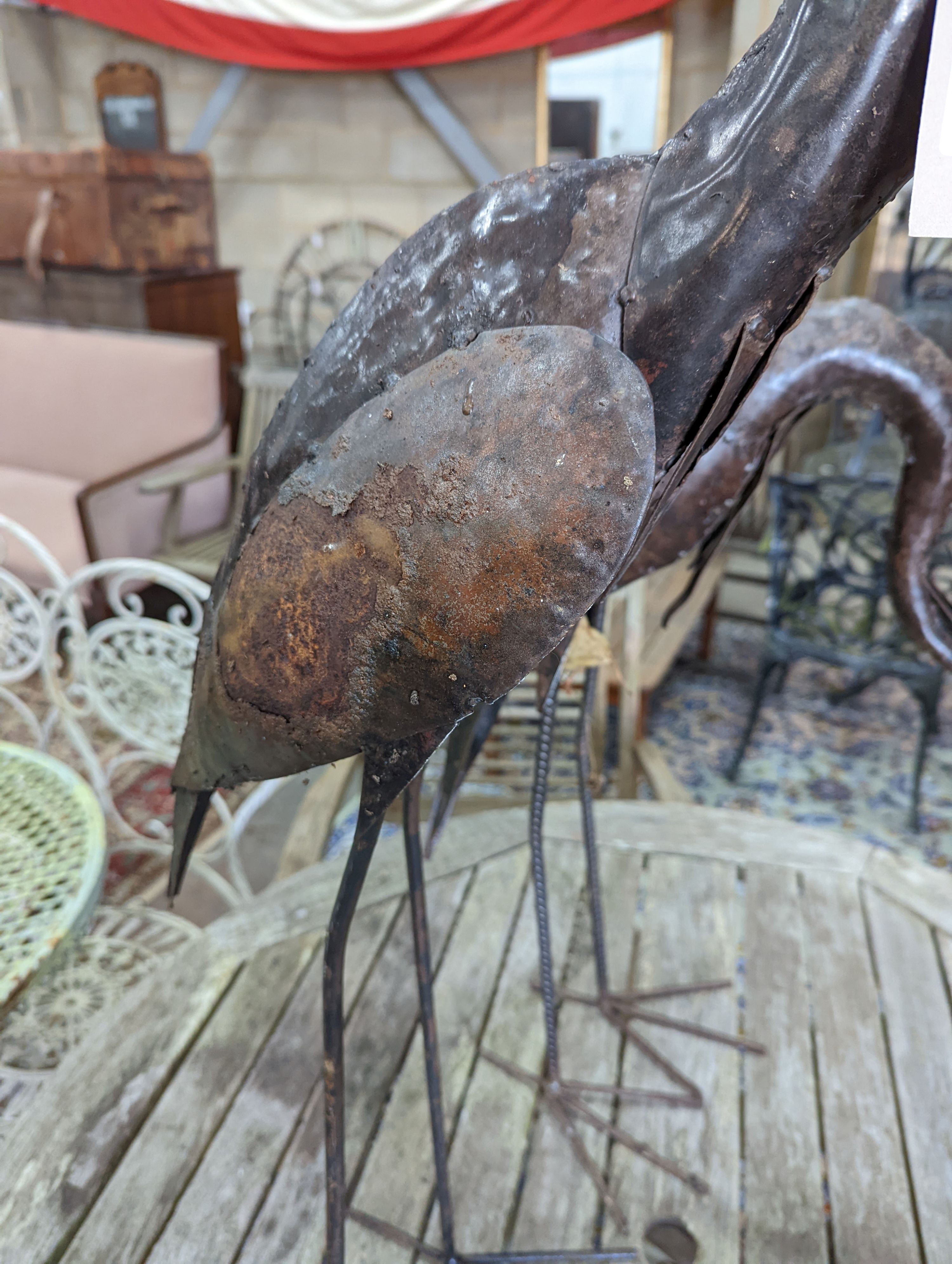 A pair of weathered metal heron garden ornaments, larger 108cm high